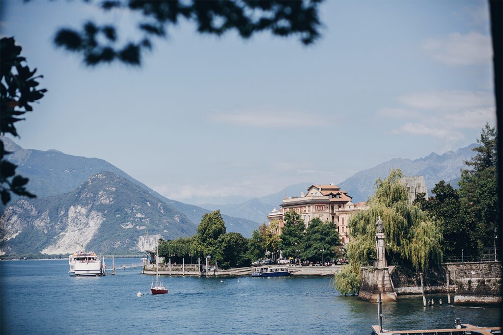 Urlaub mit Kindern am See - Aussicht auf den Lago Maggiore und ein altes historisches Gebäude, zwischen Italien und der Schweiz mit einem Bergpanorama im Hintergrund.