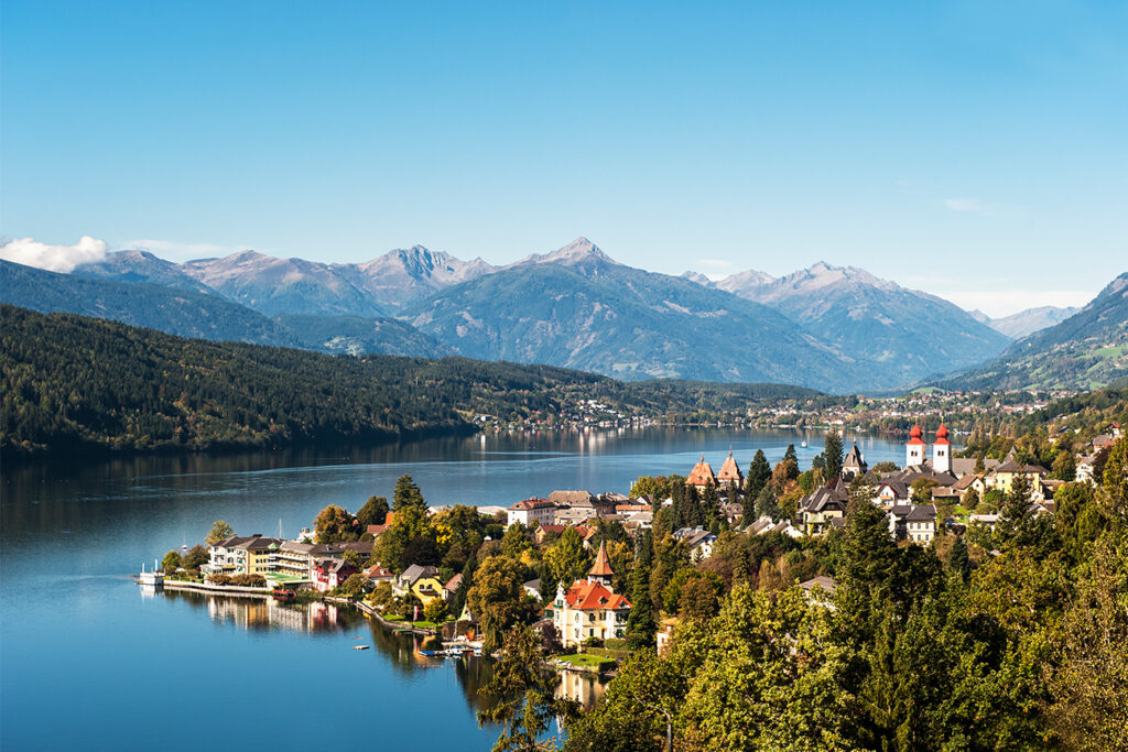 Urlaub mit Kindern am See - Aussicht auf den Millstätter See, die Stadt und das Bergpanorama im Hintergrund, in der nähe von Kärnten in Österreich.