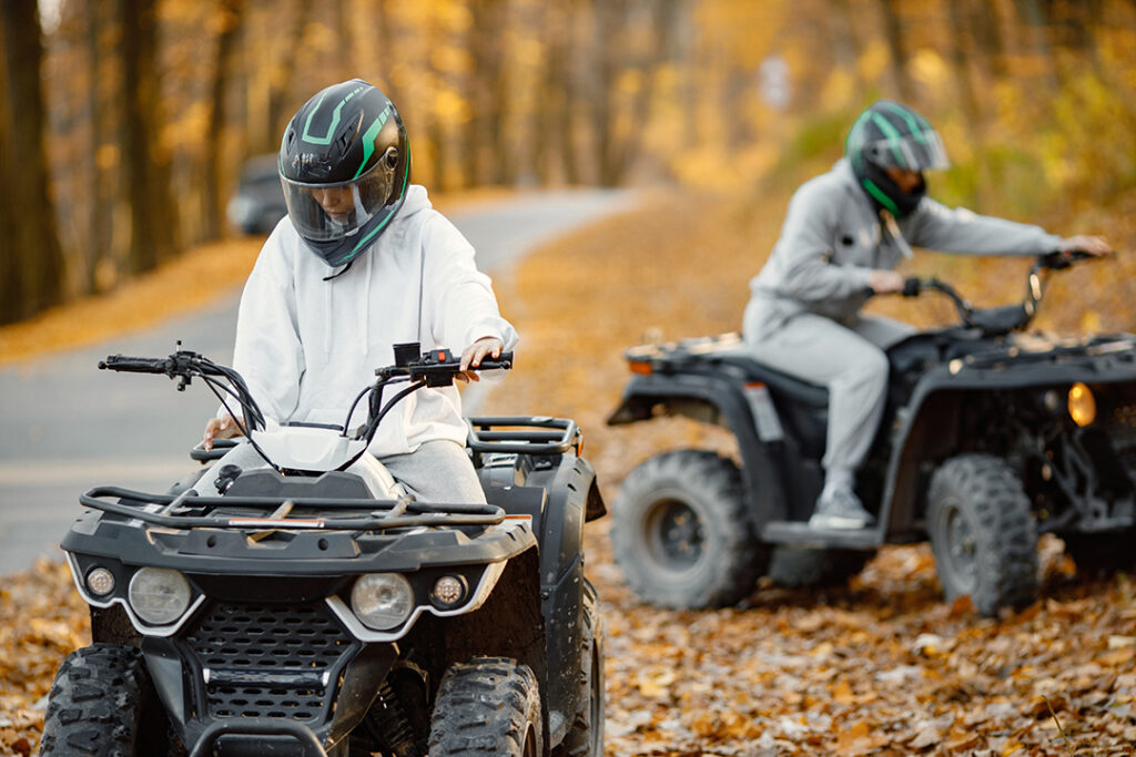 Kreative Aktivitäten für Kinder - Jugendliche fahren durch den Wald mit dem Quad bike, in Deutschland.